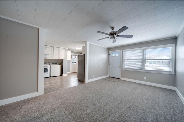 unfurnished living room with light carpet, washer and clothes dryer, ceiling fan, and ornamental molding