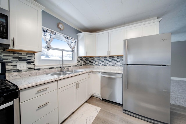 kitchen featuring light wood-type flooring, appliances with stainless steel finishes, sink, and white cabinetry