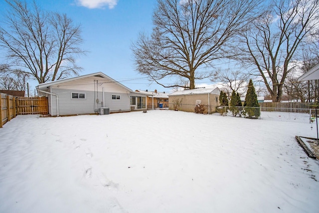 snow covered rear of property featuring cooling unit