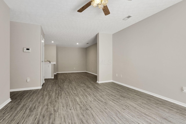 spare room with ceiling fan, dark hardwood / wood-style flooring, and a textured ceiling