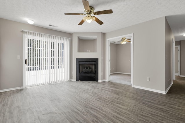 unfurnished living room featuring a textured ceiling, dark wood-type flooring, and ceiling fan