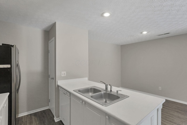 kitchen with a textured ceiling, white cabinetry, sink, stainless steel refrigerator, and white dishwasher