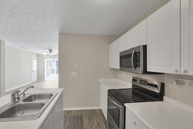 kitchen with dark hardwood / wood-style floors, sink, stainless steel appliances, a textured ceiling, and white cabinets