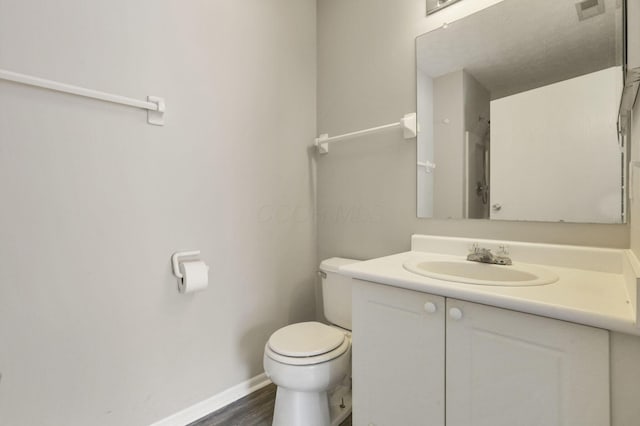 bathroom featuring wood-type flooring, toilet, and vanity