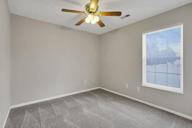 spare room featuring carpet, ceiling fan, and a textured ceiling