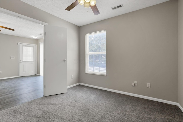 empty room featuring ceiling fan, a healthy amount of sunlight, a textured ceiling, and carpet flooring