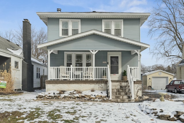 american foursquare style home featuring an outdoor structure, covered porch, and a garage