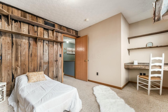 carpeted bedroom featuring a textured ceiling and wood walls