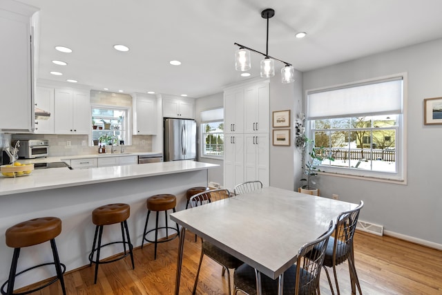 dining area with sink and light hardwood / wood-style flooring