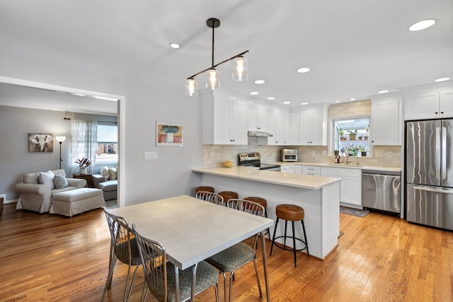 dining area featuring light hardwood / wood-style flooring, plenty of natural light, and sink