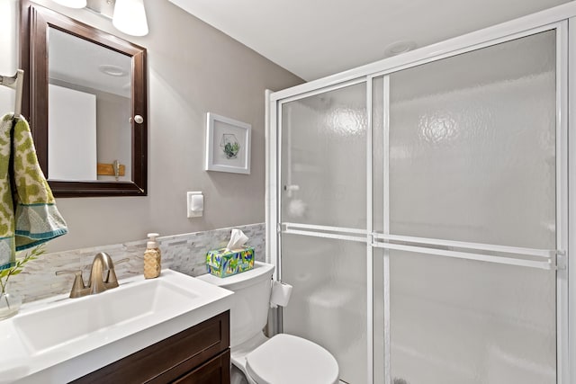 bathroom with toilet, vanity, and an enclosed shower