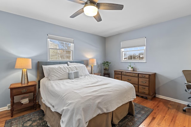 bedroom featuring light wood-type flooring, ceiling fan, and multiple windows