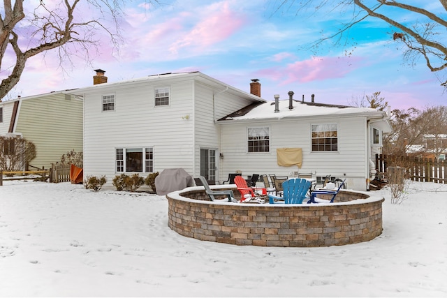 snow covered house featuring a fire pit