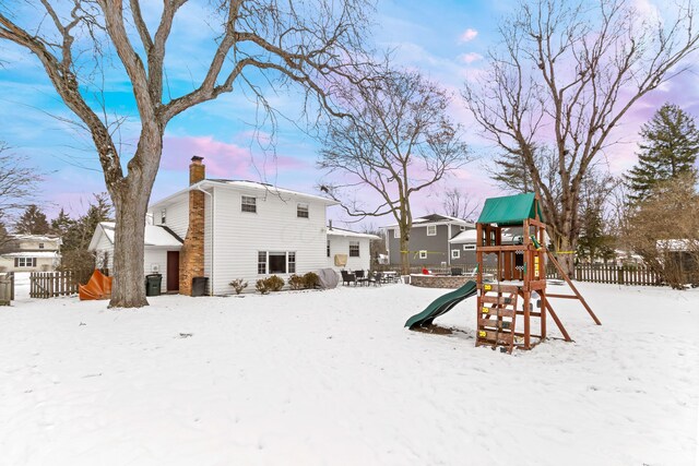 snow covered property featuring a playground