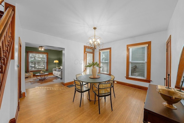 dining area with a notable chandelier and light hardwood / wood-style floors