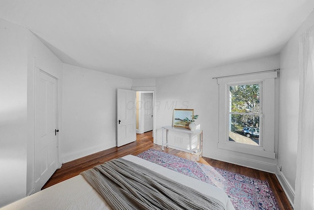 bedroom with dark hardwood / wood-style floors