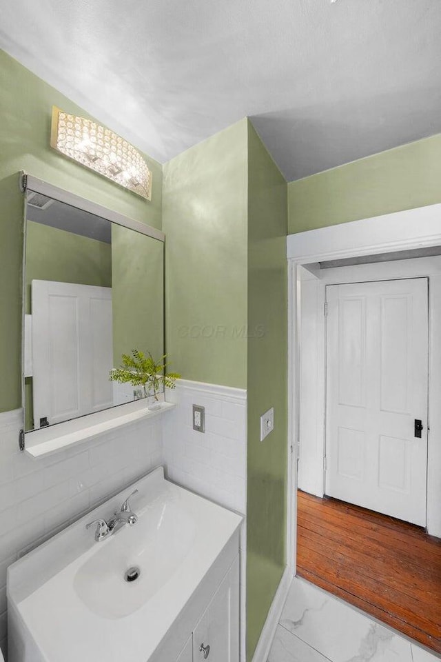 bathroom with vanity and tile walls