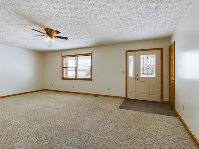 entrance foyer with ceiling fan, carpet floors, a wealth of natural light, and a textured ceiling