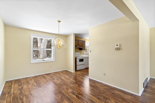 unfurnished dining area with dark hardwood / wood-style floors and a notable chandelier