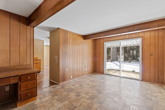 interior space with beam ceiling and wooden walls