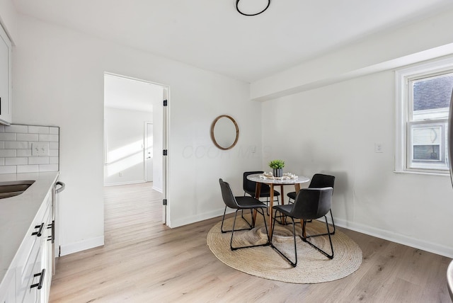 dining room featuring sink and light hardwood / wood-style floors