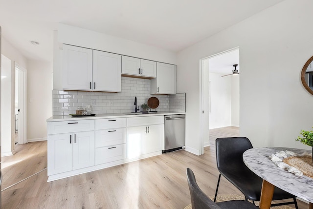 kitchen with sink, light hardwood / wood-style flooring, dishwasher, white cabinets, and decorative backsplash