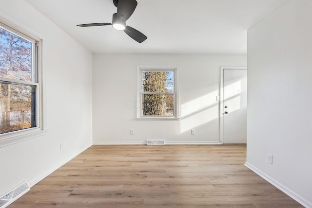 unfurnished room with plenty of natural light, ceiling fan, and light wood-type flooring