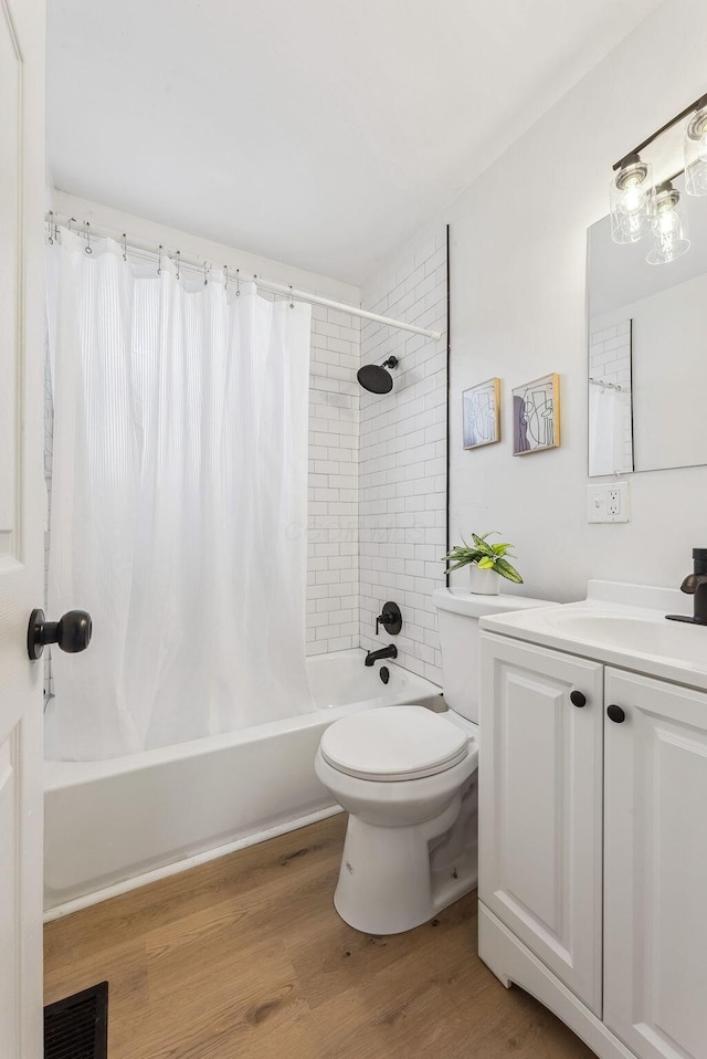 full bathroom featuring shower / tub combo with curtain, hardwood / wood-style floors, vanity, and toilet