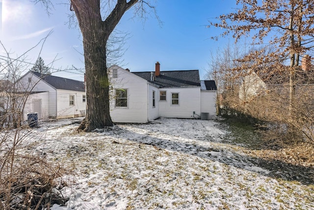 snow covered rear of property with central AC unit