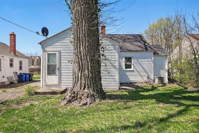 2404 Bancroft St, Columbus, OH 43211 - rear view of house featuring cooling unit, a chimney, and a lawn