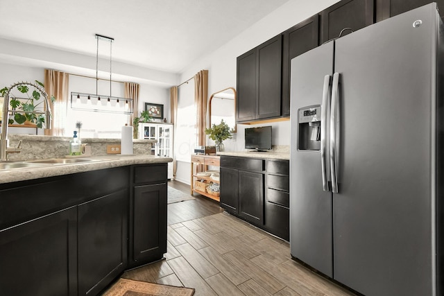 kitchen with sink, hanging light fixtures, and stainless steel fridge with ice dispenser