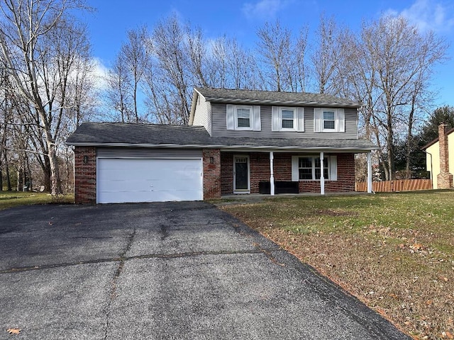 view of property featuring a front yard, a garage, and a porch