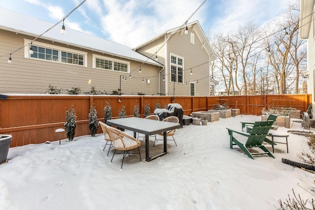 snow covered patio featuring an outdoor fire pit