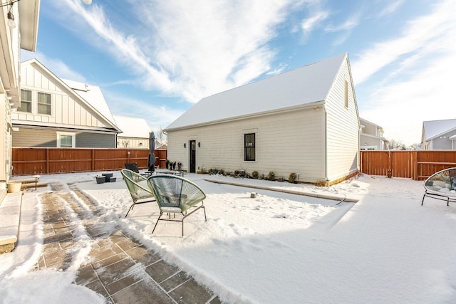 view of snow covered back of property