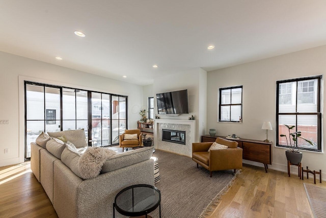 living room with a healthy amount of sunlight, hardwood / wood-style floors, and a fireplace