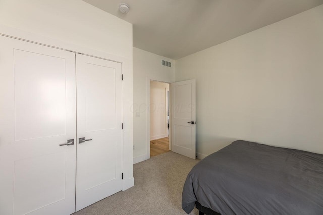 bedroom featuring light carpet and a closet