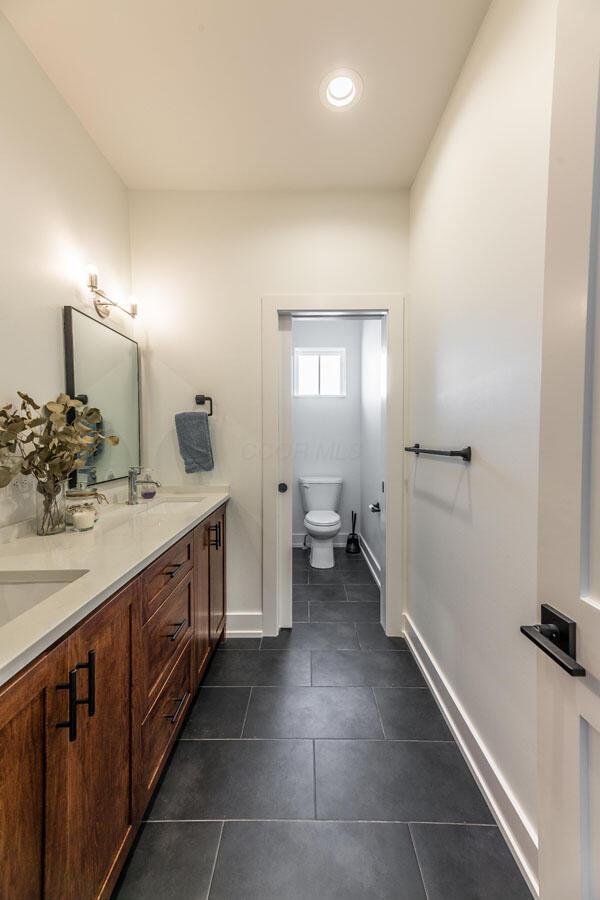 bathroom with tile patterned flooring, vanity, and toilet