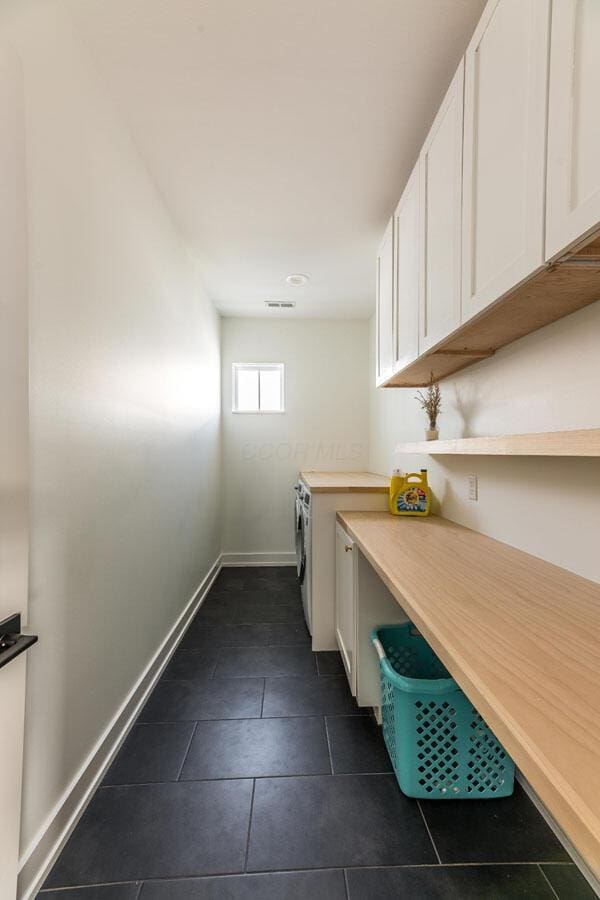 washroom featuring dark tile patterned floors and washer / dryer