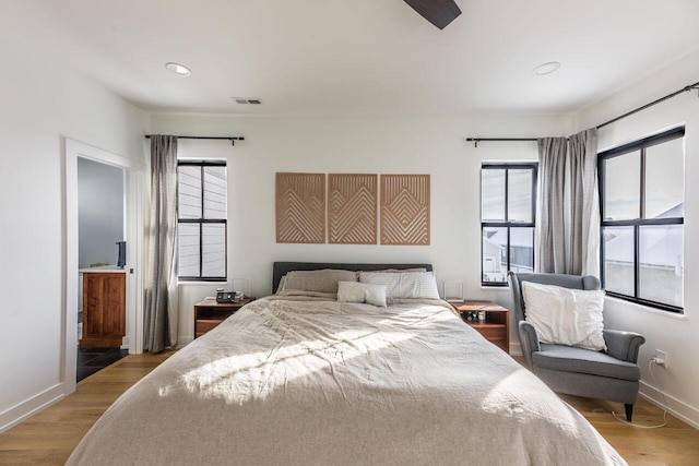 bedroom featuring multiple windows and light hardwood / wood-style flooring