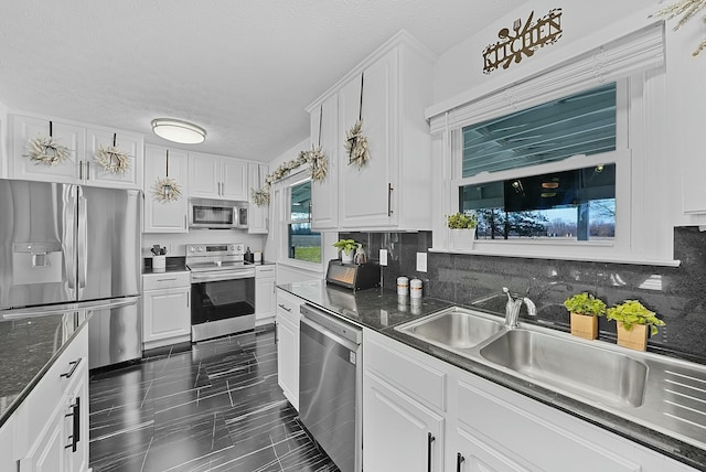 kitchen with appliances with stainless steel finishes, decorative backsplash, and white cabinetry