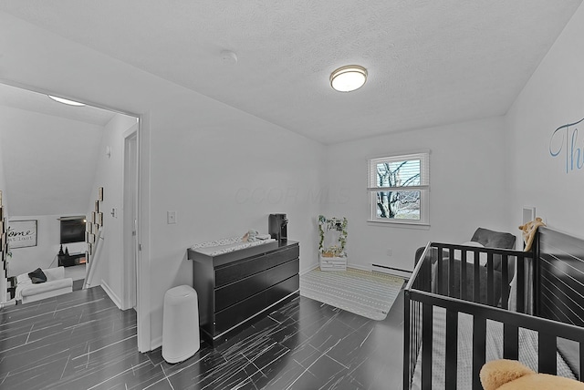 bedroom with a nursery area, a textured ceiling, and a baseboard radiator