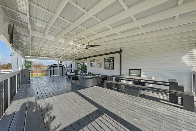 wooden deck featuring ceiling fan and a storage shed