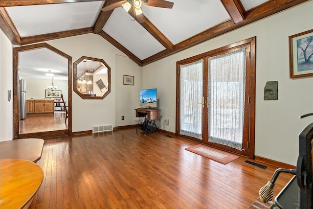 interior space featuring ceiling fan with notable chandelier, wood-type flooring, and lofted ceiling with beams