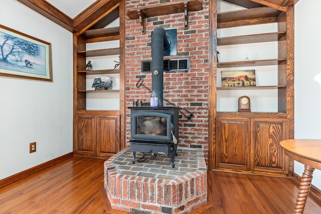 living room featuring ornamental molding, a wood stove, and hardwood / wood-style flooring