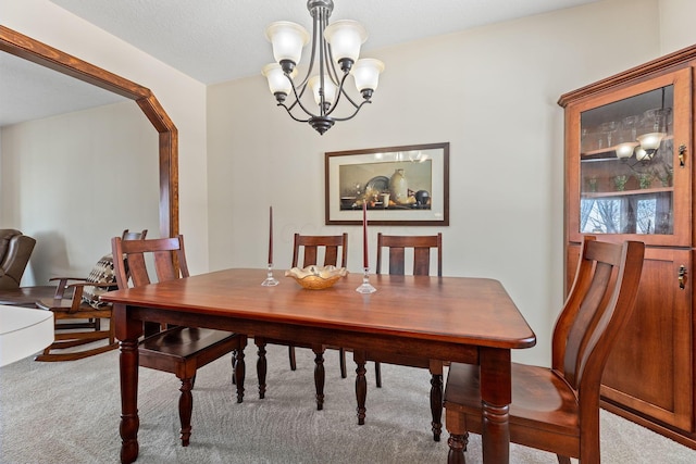 dining room featuring carpet and an inviting chandelier