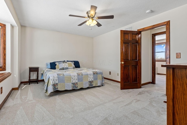 carpeted bedroom with a textured ceiling and ceiling fan