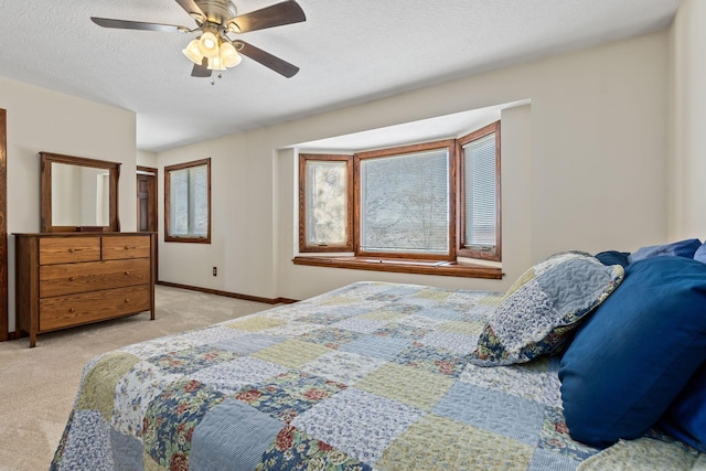 bedroom featuring light carpet, ceiling fan, and a textured ceiling