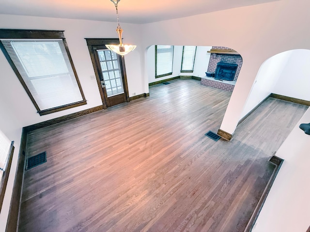 unfurnished living room with a brick fireplace and hardwood / wood-style floors