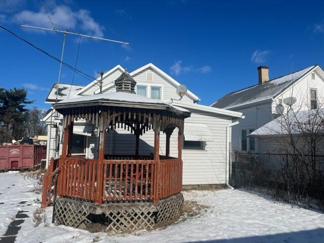 snow covered back of property with a gazebo