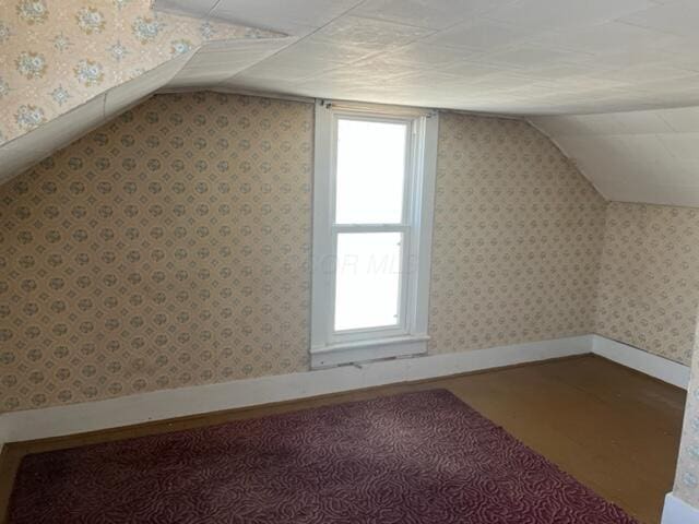 bonus room featuring hardwood / wood-style flooring and vaulted ceiling